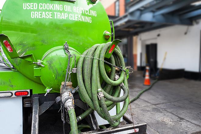 a technician pumping a grease trap in a commercial building in Taneytown, MD